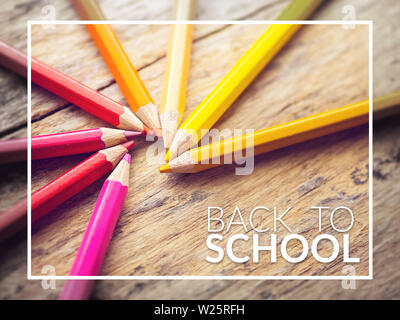 Bunte Farbstifte auf alten Holztisch mit Text Zurück zur Schule Stockfoto