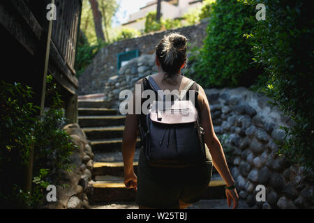 Junge Frau oben auf der Treppe der kleinen Straße des alten Plätzen. Stockfoto