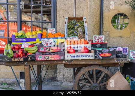 Frische Früchte zum Verkauf ausgestellt auf einem alten hölzernen Handwagen Stockfoto