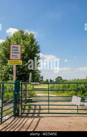 Warnschilder am Bahnübergang über die Oberseite der Bahn betrieben, Sehen, Hören'' Vorsicht vor Züge'' Reiter abbauen müssen" Stockfoto