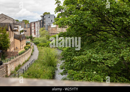 Blick hinunter eine Brücke in Stockbridge, Edinburgh, um das Wasser von Leith, mit grünen Bäumen und einem Pfad Stockfoto