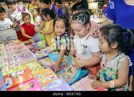 China. 6. Juli, 2019. (190706) - weihai, Juli 6, 2019 (Xinhua) - Kinder abholen Bücher mit ihren Eltern an einer Buchhandlung in Rongcheng, der ostchinesischen Provinz Shandong, 6. Juli 2019. (Foto von Li Xinjun/Xinhua) Quelle: Xinhua/Alamy leben Nachrichten Stockfoto