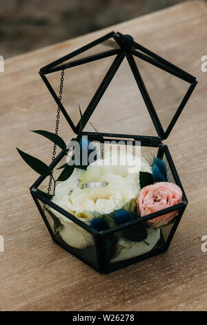 Closeup Trauringe in Weissgold oder Platin in transparenter Box mit der Weißen Rose. Traditionelle Details einer Hochzeit Fall. Stockfoto