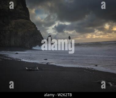 Schöne Küste des Meeres bei Vik, Island mit atemberaubenden Wolken und Felsen an der Seite Stockfoto