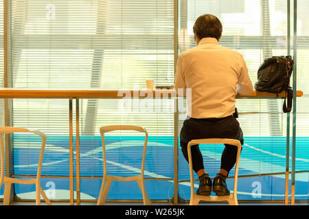 Geschäftsleute sitzen in Service Counter in Airport Lounge warten auf Abflug. Stockfoto