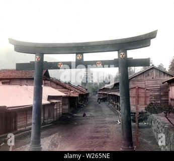 [1900s Japan - Heilige Torii-tor im Village] - ein broze Heilige torii Tor in einem Dorf in der Nähe der See Chuzenji. In der Rückseite einige Pferde gesehen werden kann. 20. Jahrhundert vintage Glas schieben. Stockfoto