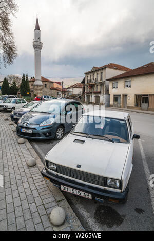 Ohrid, Mazedonien - April 2019: Reihe von privaten Autos vor Moschee Minarett in Ohrid geparkt Stockfoto