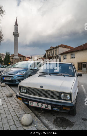 Ohrid, Mazedonien - April 2019: Reihe von privaten Autos vor Moschee Minarett in Ohrid geparkt Stockfoto