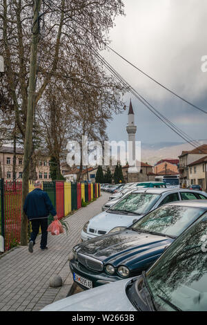 Ohrid, Mazedonien - April 2019: Reihe von privaten Autos vor Moschee Minarett in Ohrid geparkt Stockfoto