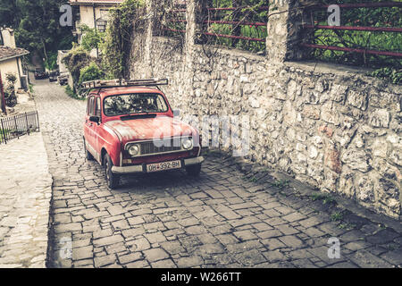 Ohrid, Mazedonien - April 2019: Kleine Retro Vintage old red Auto langsam Klettern auf einer gepflasterten Straße in der Altstadt von Ohrid Stockfoto