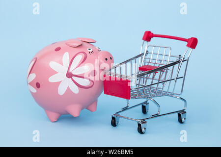 Weihnachten Geschenke in einem Supermarkt Trolley auf blauem Hintergrund mit Freiraum für Text Stockfoto
