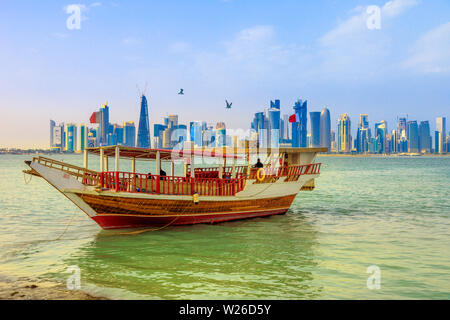 Doha, Katar - Februar 23, 2019: traditionelle Dhow und die Küste von Doha West Bay Skyline im Hintergrund mit Qatar International Exhibition Centre, Doha Stockfoto