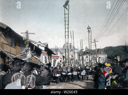 [1900s Japan - Japanische Neues Jahr - Feuerwehrmänner] - Feuerwehrmänner in happi Mäntel durchführen akrobatischen Stunts auf Bambus Leitern vor hyogo Prefectural Office in Kobe, Hyogo Präfektur. Die Leiter Stunts waren die wichtigsten Ereignis der Japanischen ins neue Jahr feiern. Die Demonstrationen, die sogenannten Dezome-shiki, waren dazu gedacht, die Menschen auf die Gefahren des Feuers zu warnen und die Flexibilität und den Mut der Feuerwehrleute zu demonstrieren. Dieses Bild ist Teil des neuen Jahres in Japan, ein Buch von Kobe veröffentlicht Fotograf Kozaburo Tamamura 1906 (Meiji 39). 20. Jahrhundert vintage Lichtdruck drucken. Stockfoto