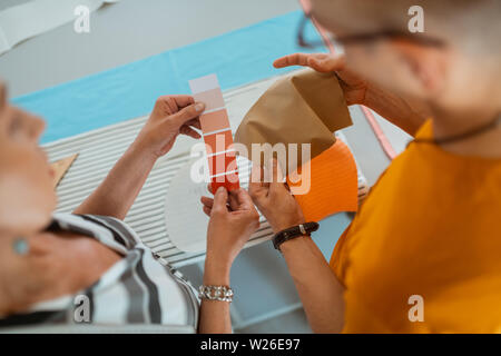 Generierung von Ideen. Zwei moderne Modedesigner holding Farbmuster, während Sie eine Farbpalette für eine neue Sammlung Stockfoto