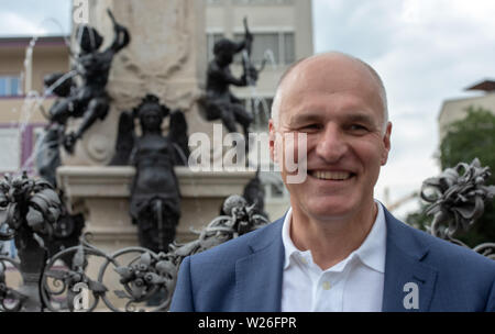 Augsburg, Deutschland. 06 Juli, 2019. Augsburgs Oberbürgermeister Kurt Gribl (CSU) steht Lachen neben dem Augustus Brunnen. Die Unesco hat die Wasserwirtschaft in Augsburg als Weltkulturerbe anerkannt. Der Ausschuß umfaßt die historische Wasserversorgung, die einst von den Römern gegründet wurde, auf der Liste des Weltkulturerbes. Quelle: Stefan Puchner/dpa Quelle: dpa Picture alliance/Alamy Live News/dpa/Alamy leben Nachrichten Stockfoto