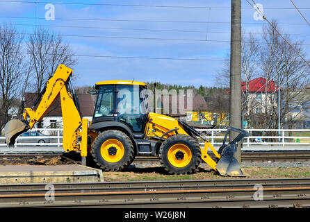 Gelben bulldozer trägt Aushubarbeiten durch, während der Konstruktion und Rekonstruktion von Schienen und Titel auf der Bahn Stockfoto