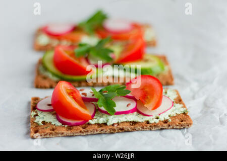 Leckere Ernährung Sandwiches mit Quark mit Kräutern und Gemüse auf weißem Hintergrund Stockfoto