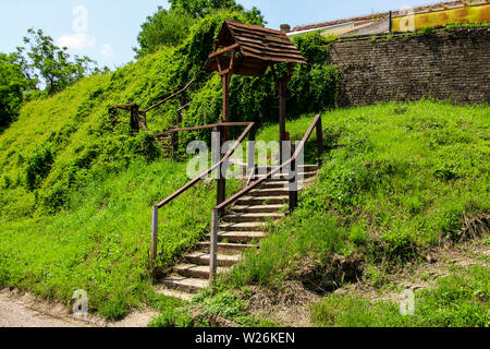 Hölzerne Treppe, die zu einem Übergang in eine Mauer Stockfoto