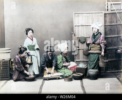 [1890s Japan - Japanische Frauen kochen] - In diesem Studio Foto der täglichen Küche, vier Frauen im Kimono typisch japanische Küche Aufgaben zeigen, die Frau auf der linken Seite ist das Schleifen etwas in einem suribachi (Mörtel). Die Frau, die neben ihrem hält eine Gusseisen Teekanne), während die Frau in der Mitte ist Schneiden daikon Rettich (Japanisch). 19 Vintage albumen Foto. Stockfoto