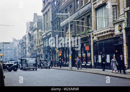 New Bond Street in den 1950er Jahren, das Bild zeigt die Juweliere J W Benson Ltd zusammen mit einer Werbung für Elizabeth Arden über den Shop Fassade. Die Hackney Carriage (London Black Cab Taxi) ist auch sichtbar in einer früheren Inkarnation Beardmores und Austin FX3 wurden die wichtigsten Träger des Tages. Stockfoto