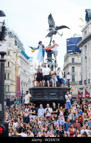 London, Großbritannien. 6. Juli 2019. Piccadilly Circus ist ein beliebter Ort der Pride Parade in London Pass mit Menschen klettern Ampel und die Statue des Eros eine gute Sicht am Samstag, Jan. 6, 2019 zu gewinnen. Bild von Julie Edwards - Kreditkarten: Julie Edwards/Alamy leben Nachrichten Stockfoto