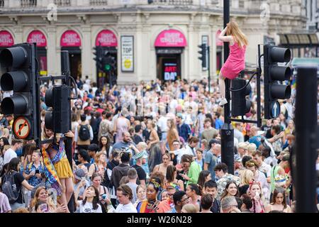 London, Großbritannien. 6. Juli 2019. Piccadilly Circus ist ein beliebter Ort der Pride Parade in London Pass mit Menschen klettern Ampel und die Statue des Eros eine gute Sicht am Samstag, Jan. 6, 2019 zu gewinnen. Bild von Julie Edwards - Kreditkarten: Julie Edwards/Alamy leben Nachrichten Stockfoto