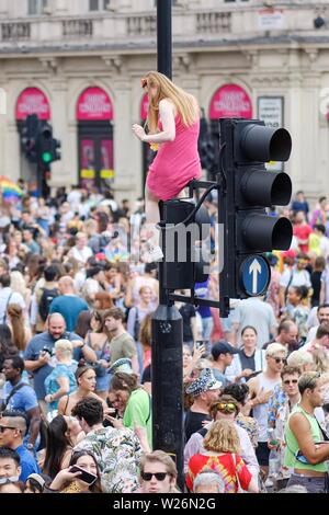 London, Großbritannien. 6. Juli 2019. Piccadilly Circus ist ein beliebter Ort der Pride Parade in London Pass mit Menschen klettern Ampel und die Statue des Eros eine gute Sicht am Samstag, Jan. 6, 2019 zu gewinnen. Bild von Julie Edwards - Kreditkarten: Julie Edwards/Alamy leben Nachrichten Stockfoto