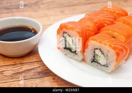 Brötchen mit Lachs Soja Sauce auf einer Platte Stockfoto