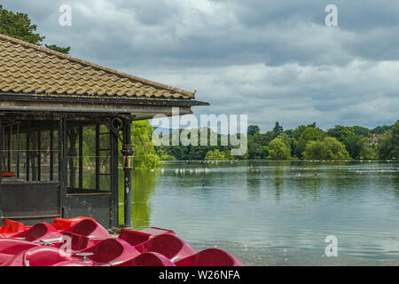 Roath Park See in der Hauptstadt von Wales, Cardiff, mit den umgebenden Bäumen und einer der Bootshäuser, South Wales Stockfoto