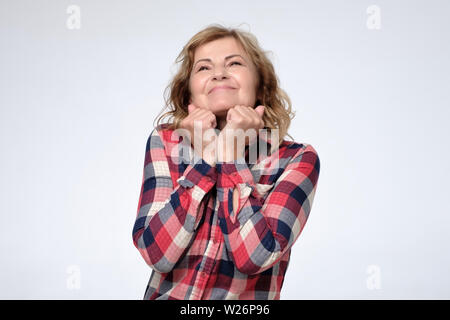 Kaukasische reife Frau mit Aufregung auf Kamera positive Pläne für die Zukunft. Studio gedreht. Positive facial menschliches Gefühl. Stockfoto