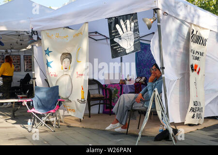 Eine psychische Palm Reader Wahrsagerin wartet für Kunden, die an einer im Zelt bei einem Outdoor festival Messe in Spokane, Washington Stockfoto