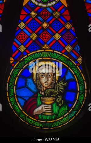 Detail von St. John in der kreisförmigen Glasfenster in der Kathedrale von Lissabon, Portugal gezeigt Holding einen Kelch mit kleinen Drachen trinken aus. Stockfoto