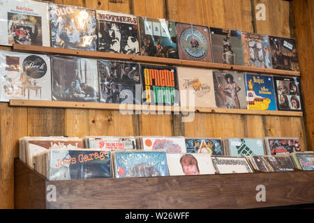 LPs und Schallplatten auf einer Wand in einem Plattenladen zum Verkauf ausgestellt Stockfoto