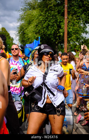 Performerin gekleidet, wie ein Polizist in der Parade an der St Pauls Karneval, Bristol, 6 Juli 2019 marschieren Stockfoto