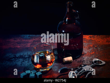 Bar oder pub Stilleben mit Karaffe und Glas Whiskey neben Schwarz shungite kühlen Eiswürfel oder wiederverwendbare Eisblöcke auf einem vintage Holz Zähler in s Stockfoto