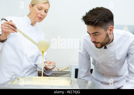 Koch dekorieren beendete zwei Kuchen von Schokolade und Sahne Stockfoto