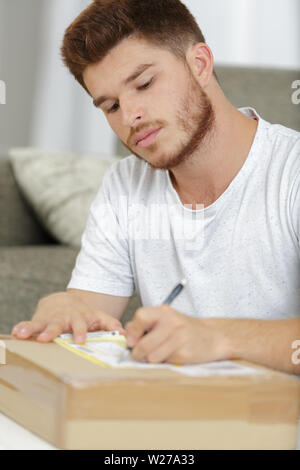 Junge Mann laufen Unternehmen von zu Hause aus Kennzeichnung Ware Stockfoto