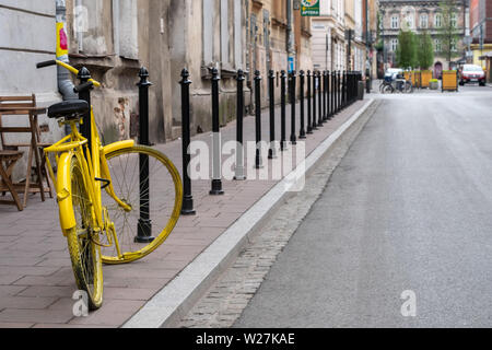 Typische Straßenszene in Krakau, Polen. Gelbe bikeparked außerhalb einer Coffee Shop in der Nähe des Plac Nowy (Neuer Platz) in Kazimierz, dem historischen jüdischen Viertel. Stockfoto