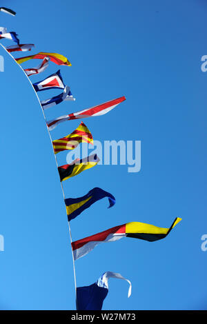 Meer Flaggen im Wind flattern vor blauem Himmel Stockfoto