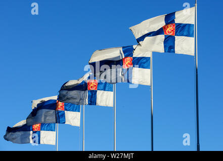 Wehenden Fahnen von Finnland gegen den blauen Himmel Stockfoto