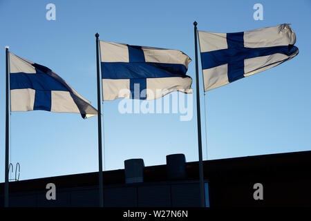 Wehenden Fahnen von Finnland gegen den blauen Himmel Stockfoto