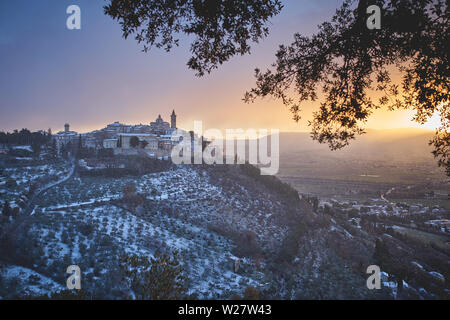 Luftaufnahme der Stadt Trevi in der Region Umbrien (Italien) mit Schnee bei Sonnenuntergang. Reisen und saisonale Konzept. Querformat. Stockfoto