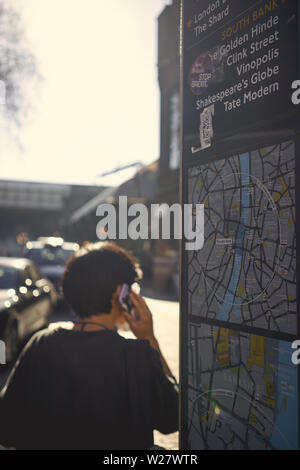 London, UK - Februar, 2019. Ein Tourist auf der Suche nach Informationen in der Nähe von einem Totem in Borough Market. Stockfoto