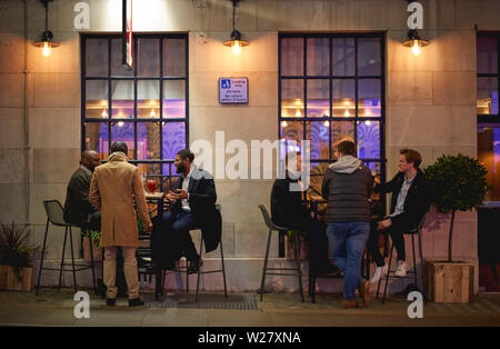 London, UK - Februar, 2019. Junge Menschen, die Getränke in einem Pub an einem Freitag Abend nach der Arbeit. Stockfoto