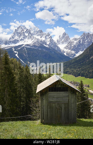 Einen typischen hölzernen Scheune (Tabia in Italienisch) mit den Dolomiten Alpen im Hintergrund. Hochformat. Stockfoto