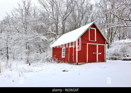 Malerische Aussicht mit roten Scheunen in der durch frischen Schnee Wald bedeckt. Morgen nach Blizzard. Landwirtschaft, Landwirtschaft und ländlichen Lebens im Winter Hintergrund. Stockfoto