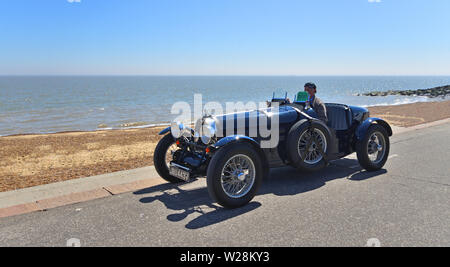 Classic blau Bugatti Rennwagen entlang der Strandpromenade gefahren wird. Stockfoto