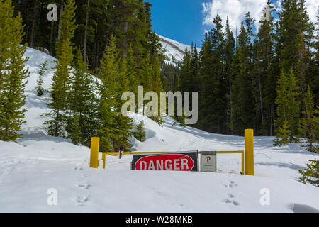 Warnschild Sperrung einer Straße in einem Snowbank in einem Bergwald Stockfoto