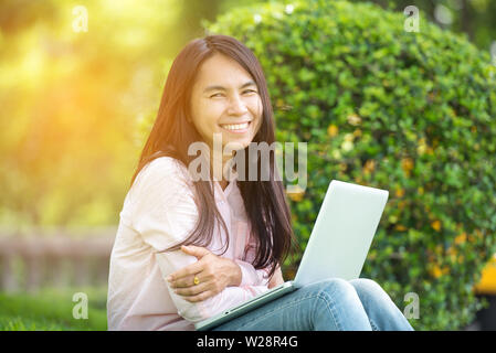 Schöne wirtschaft Frau mit Iphone Ipad während der Arbeit mit dem Laptop und lesen Bericht, Diagramme, Schaubilder, Dokument bei der Arbeit. Business woman nicht Stockfoto