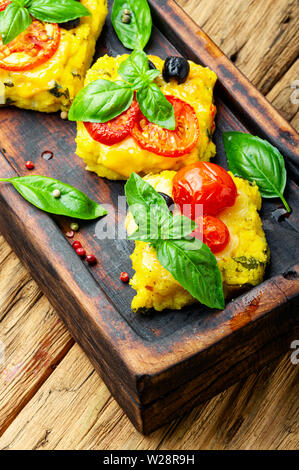 Polenta mit Tomaten und Käse. Italienische Küche. Stück Mais polenta Stockfoto